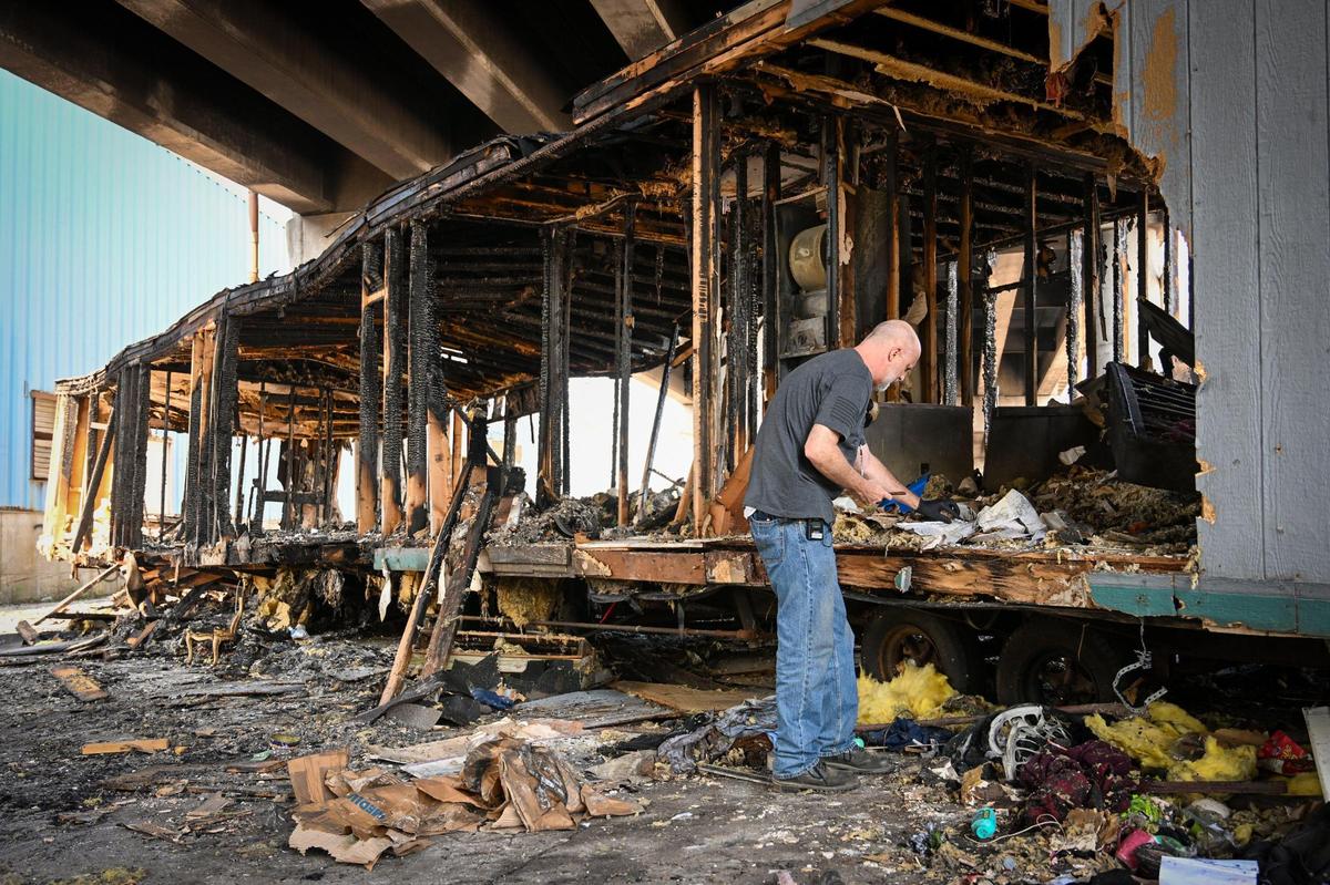 Alan Ashurst, an illegal dumping investigator for Kansas City, looks through paperwork Monday, Aug. 1, 2022, at a mobile home illegally dumped under the 23rd Street bridge at Manchester Trafficway.