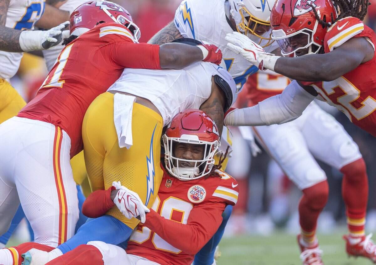 Kansas City Chiefs cornerback L'jarius Sneed (38) brings down Los Angeles Chargers running back Omarion Hampton (8) during the first half on Sunday at Arrowhead Stadium.