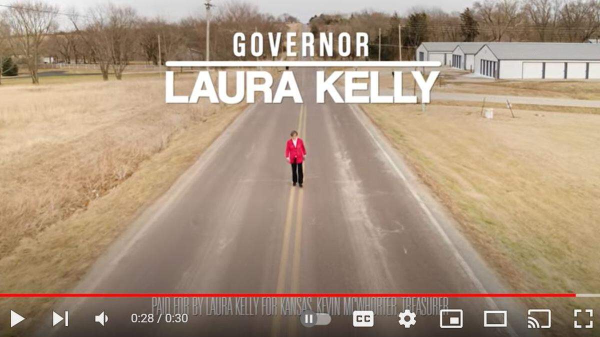 Kansas Gov. Laura Kelly walks down the middle of a road in an advertisement for her 2022 reelection campaign.