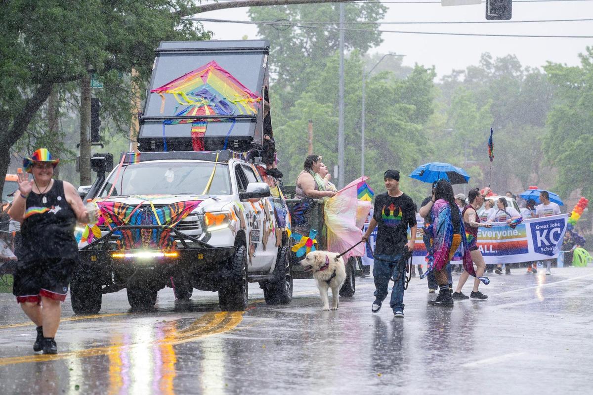 Heavy rain falls as parade participants continue walking during the KC Pride Parade.