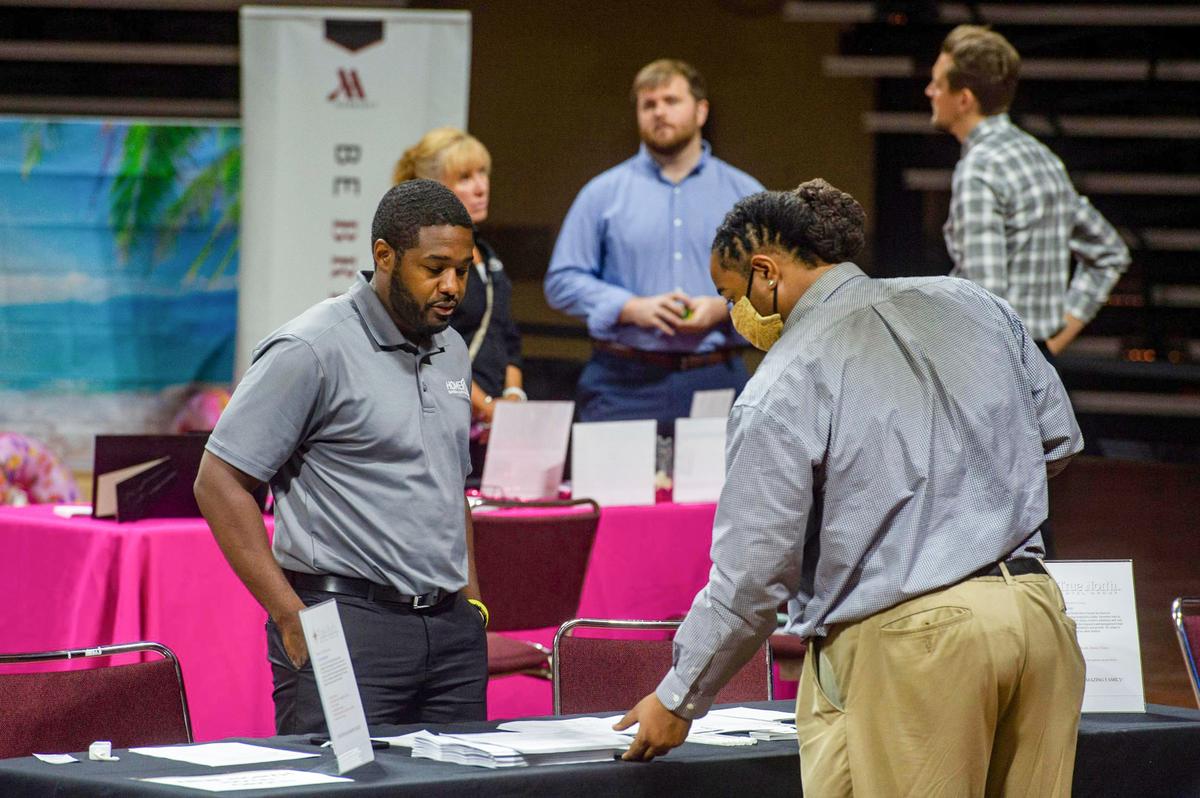 David Betts, right, talked with hospitality business representatives at an industry job fair Thursday at Municipal Auditorium in Kansas City. More than 40 hotels, casinos, suppliers and restaurants were looking to hire employees. Betts had three to five years of hospitality experience before COVID-19 began.