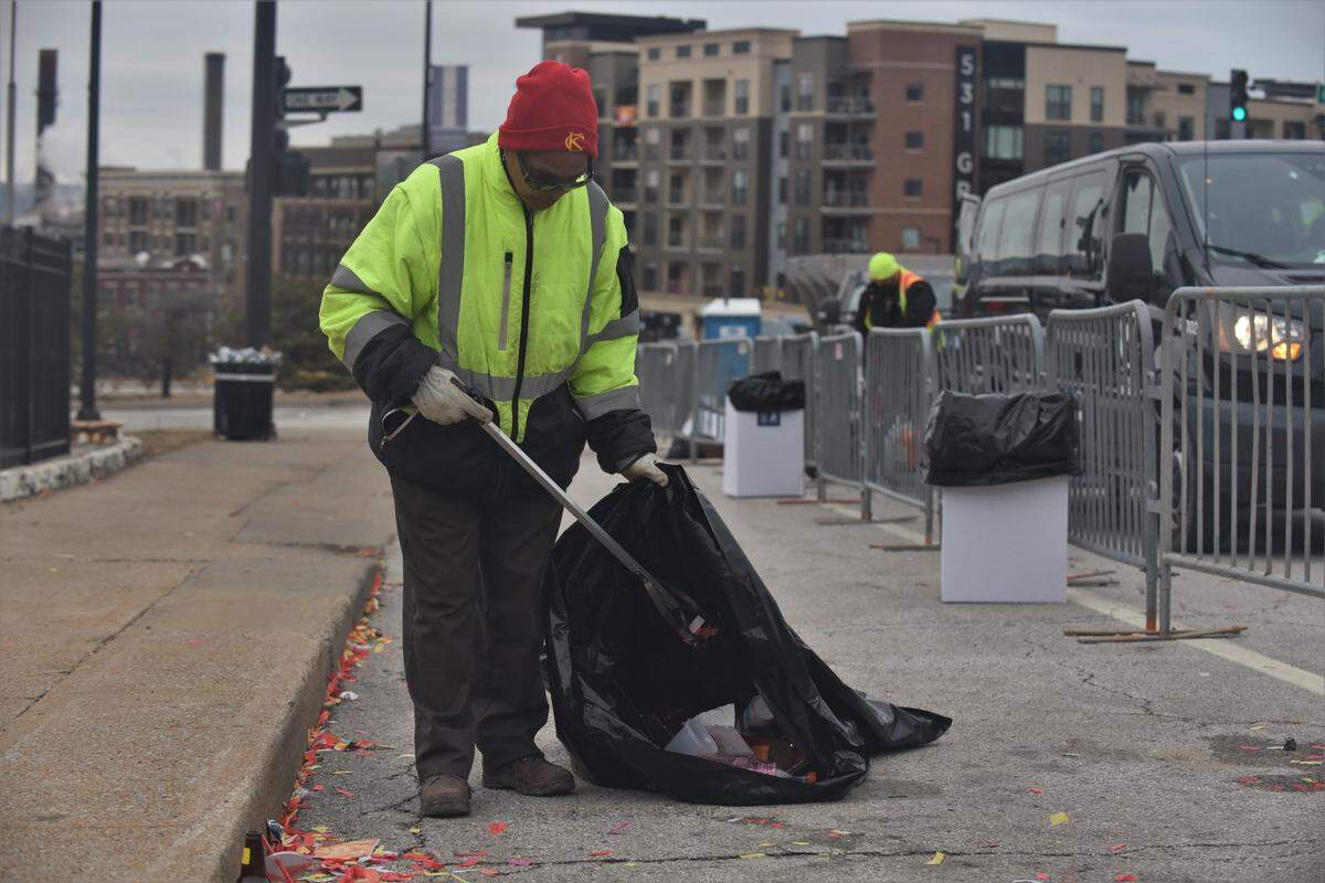 Toni Brown, a Kansas City employee, picks up trash near Sixth Street and Grand Boulevard following the Chiefs Super Bowl victory parade.