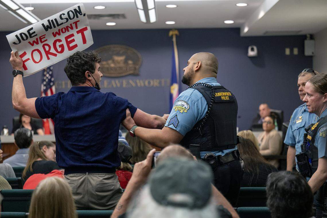 A protester was removed from a meeting of the Leavenworth city commission, which approved a zoning permit Tuesday, March 10, 2026, that allows a private prison company, CoreCivic, to reopen its shuttered prison on the outskirts of town as an ICE detention center. 