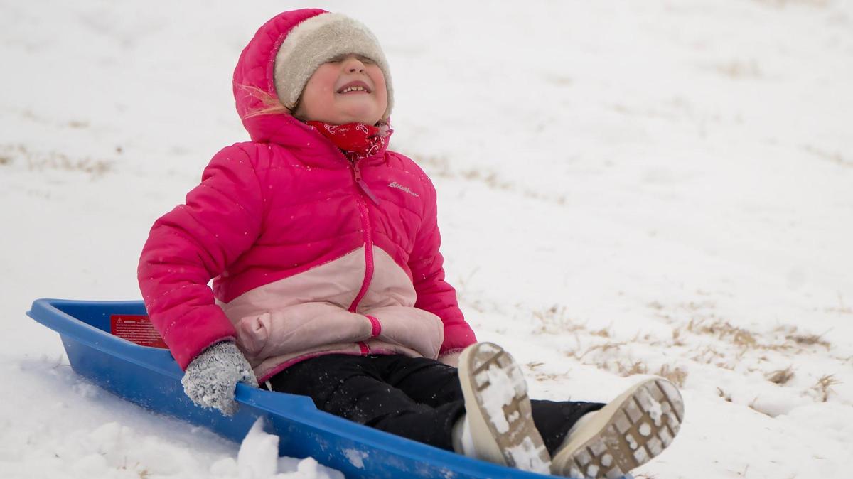 After an overnight storm blanket the area with snow, Isla Huschka, 6, of Prairie Village, closed her eyes and gripped her sled as she went down the hill at Meadowbrook Park in Prairie Village on Wednesday, Feb. 12, 2025. Isla had a day off of Prairie Elementary School because of the winter weather.