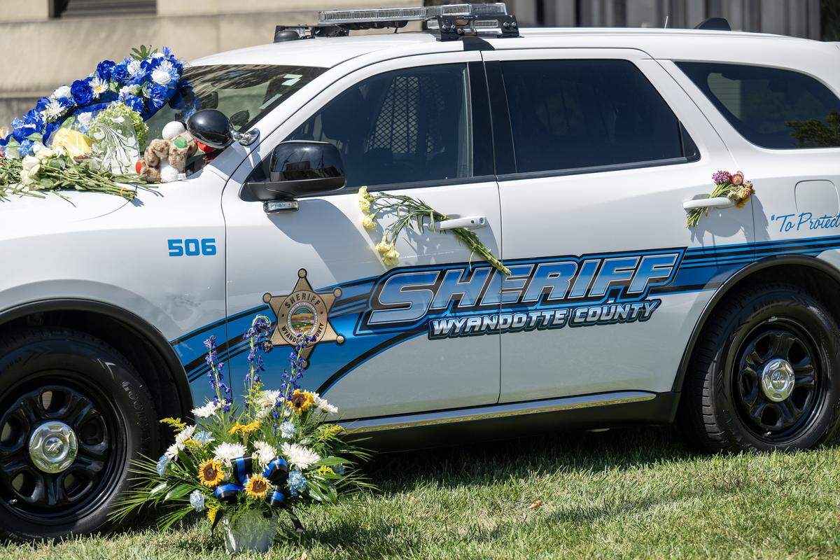 A growing memorial of flowers and tributes appeared on the vehicle honoring Deputy Elijah Ming on Tuesday, July 29, 2025, in Kansas City, Kansas. Ming, 34, was fatally shot on Saturday, July 26, 2025, while responding to a domestic violence call.
