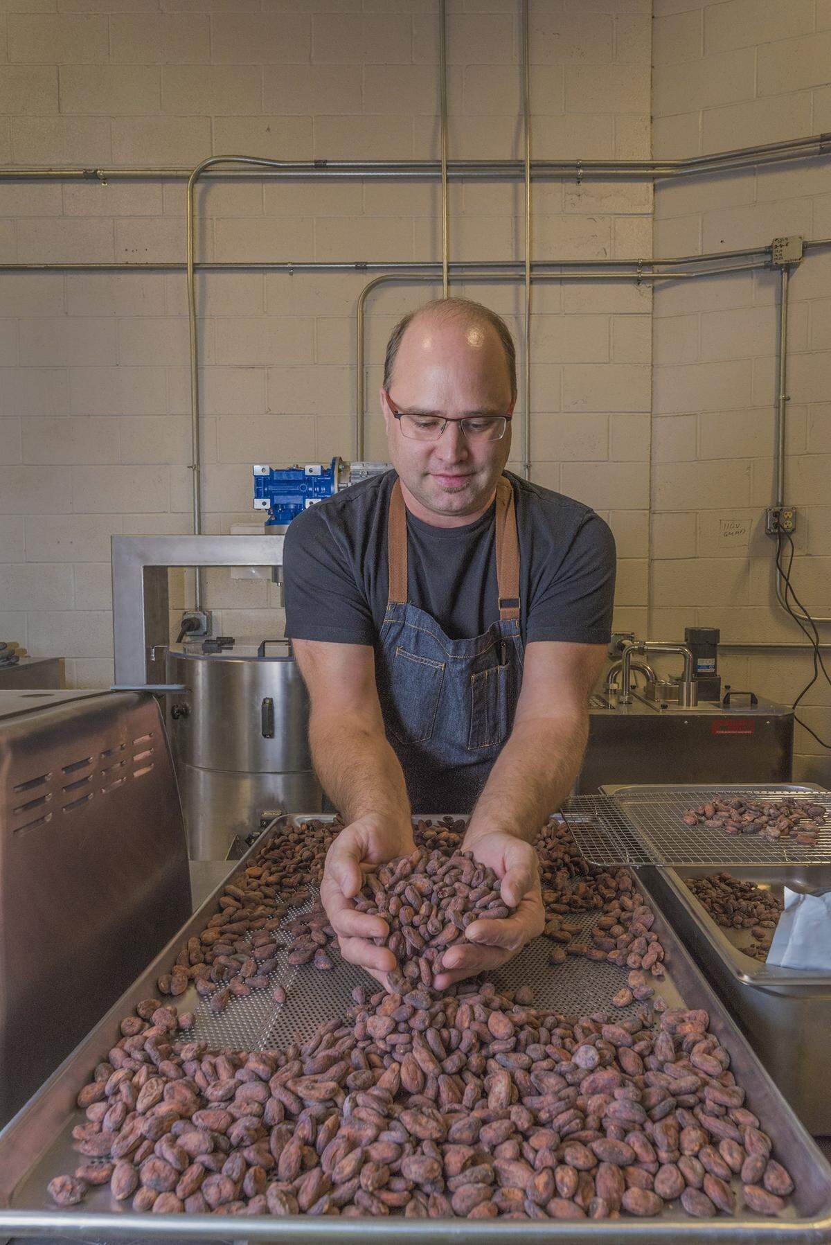 Christopher Elbow sorts chocolate beans as the first step in creating a new line of chocolates.