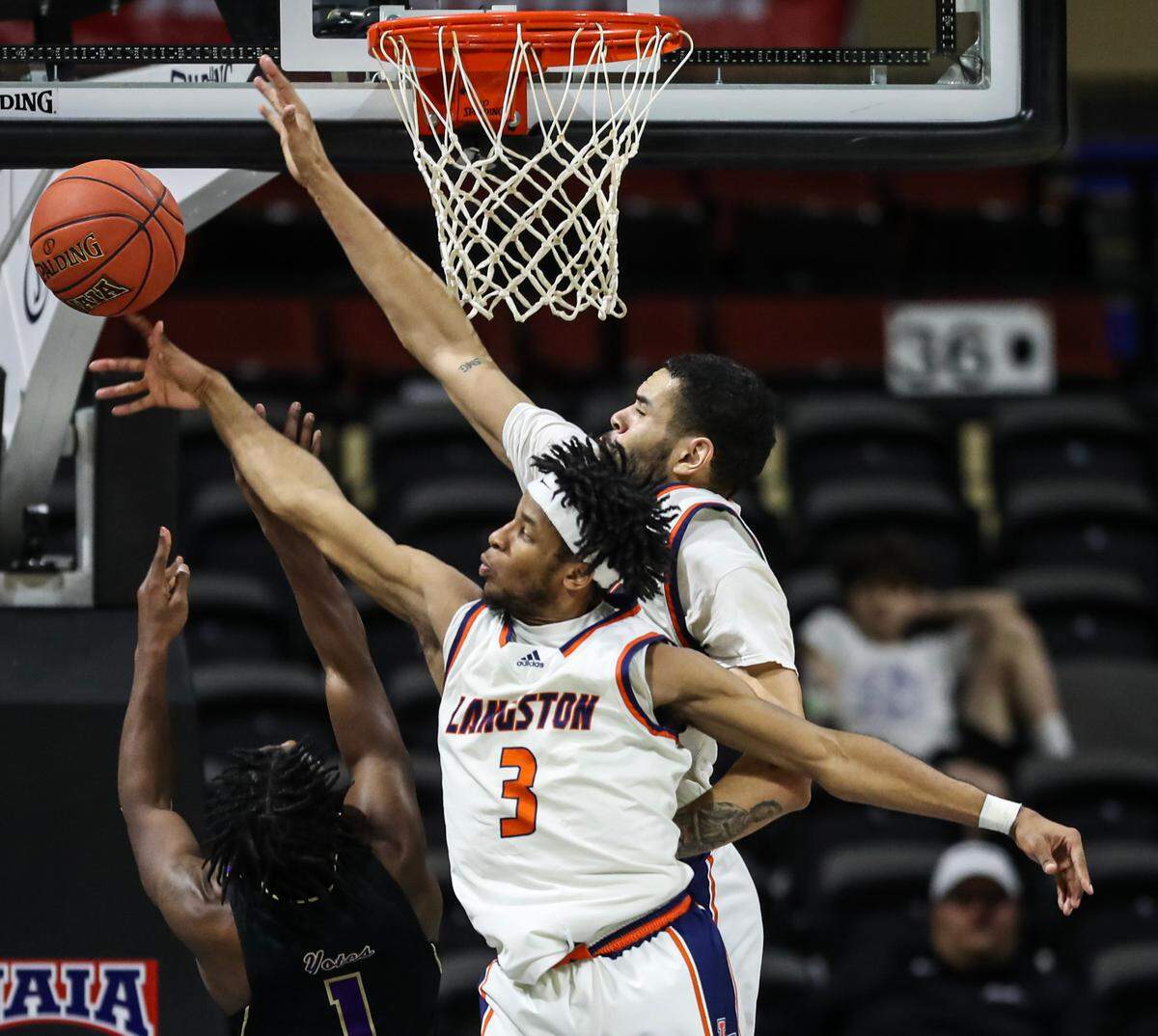 Toru Dean of Langston defends a shot from the College of Idaho’s Samaje Morgan in the NAIA semifinals on Monday night at Municipal Auditoruim.