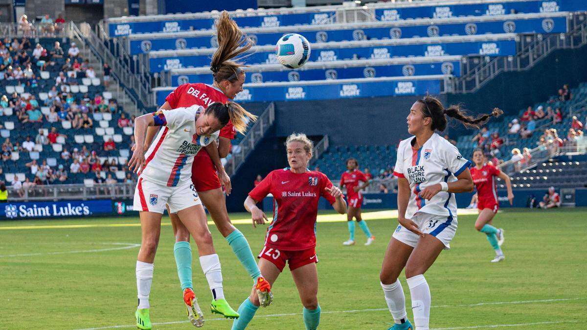 Kansas City Current forward Kate Del Fava fights OL Reign players for the ball during a recent evening match at Children’s Mercy Park in Kansas City, Kansas.
