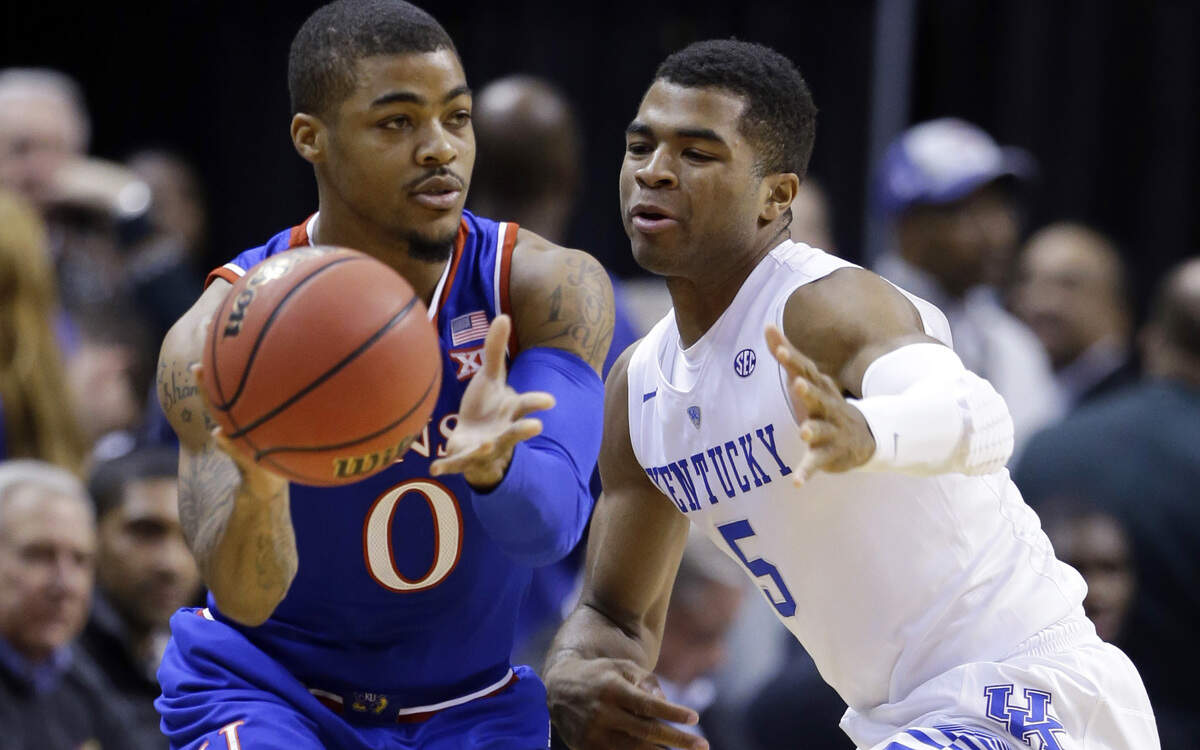 Kansas's Frank Mason III, left, makes a pass around Kentucky's Andrew Harrison in the first half of an NCAA college basketball game in Indianapolis, Tuesday, Nov. 18, 2014. 