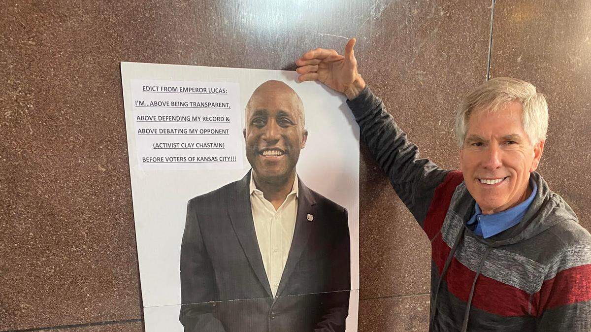 Kansas City mayoral candidate Clay Chastain with a poster of his opponent Mayor Quinton Lucas at Union Station on Friday.