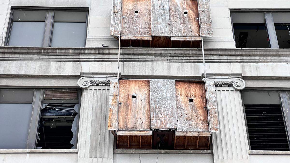 The once-proud façade of 925 Grand is now marked by shattered glass and plywood, as pigeons roost inside the abandoned Federal Reserve building, adding to its deepening decay.
