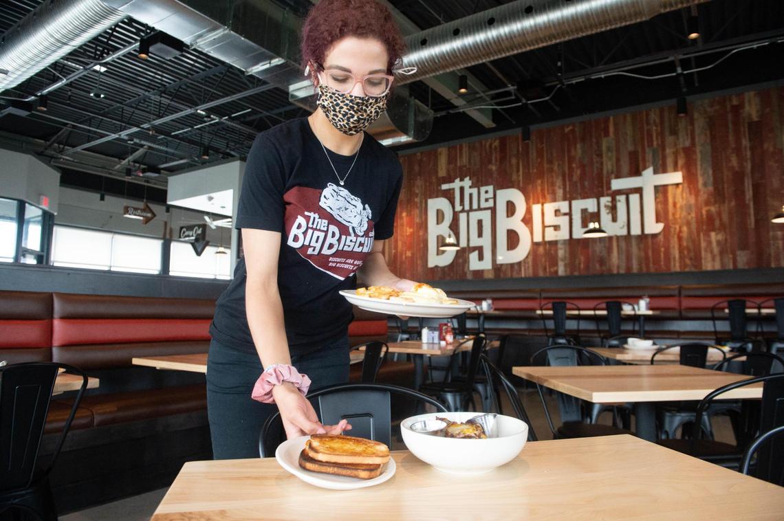 Karly Shorter sets food on the table during a training at the new The Big Biscuit restaurant in Lenexa as the restaurant prepares to open on May 1. Shorter started working at another Big Biscuit restaurant last October and was called to help out at this new location because the restaurant owner can’t find enough workers to hire.