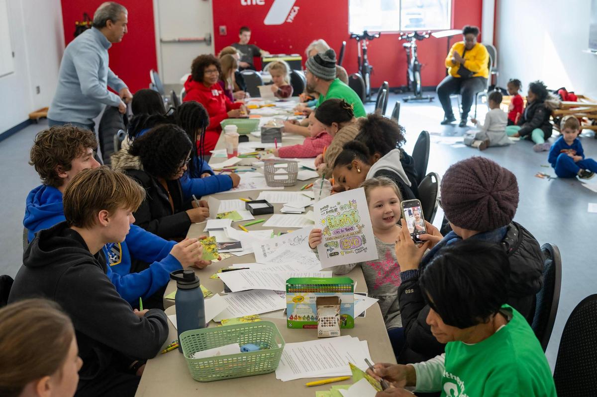 Volunteers turned out to write thank you cards to veterans and others during a Day of Service honoring Dr. Martin Luther King Jr. at the Cleaver Family YMCA, 7000 Troost Ave., on Monday, Jan. 20, 2025, in Kansas City. Marianne Kunkel of North Kansas City took a photo of her daughter, Zora Nall, 4, right, during the event.