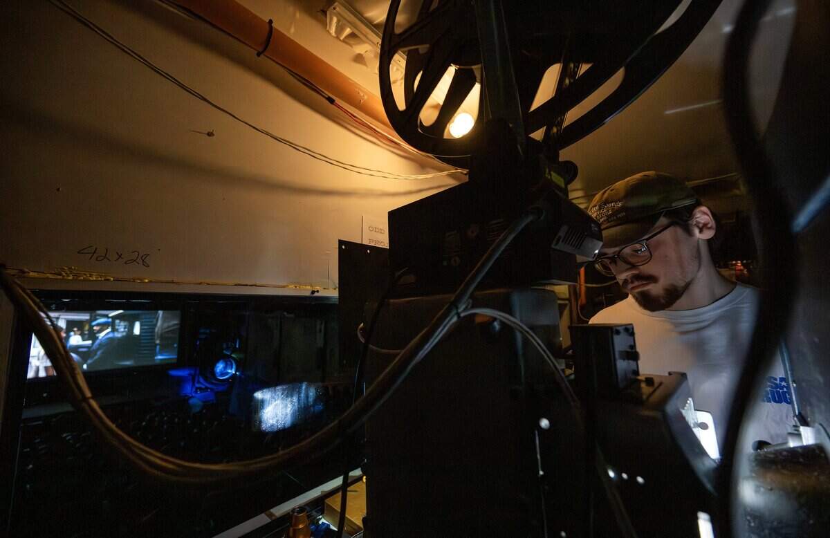 Projectionist Ethan Foster tightens a knob to steady the 70mm film during a screening of “Sinners” at Screenland Armour Theatre on Friday, March 27, 2026, in North Kansas City.
