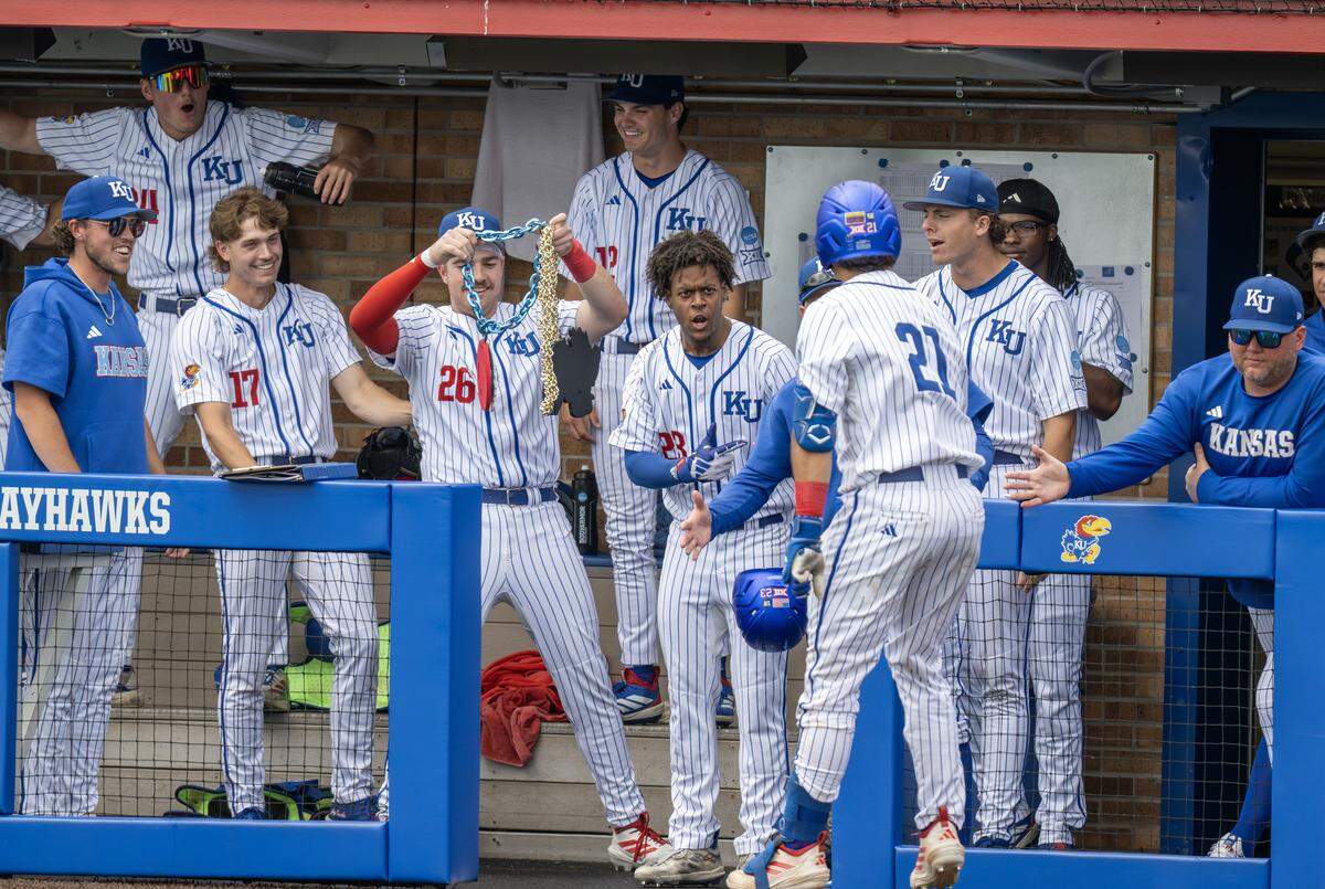 Kansas Jayhawks teammates celebrate with catcher Augusto Mungarrieta (21) in the dugout after he hit a home run against the Northeastern Huskies in the second inning of an NCAA baseball tournament game at Hoglund Ballpark on Friday, May 29, 2026, in Lawrence.