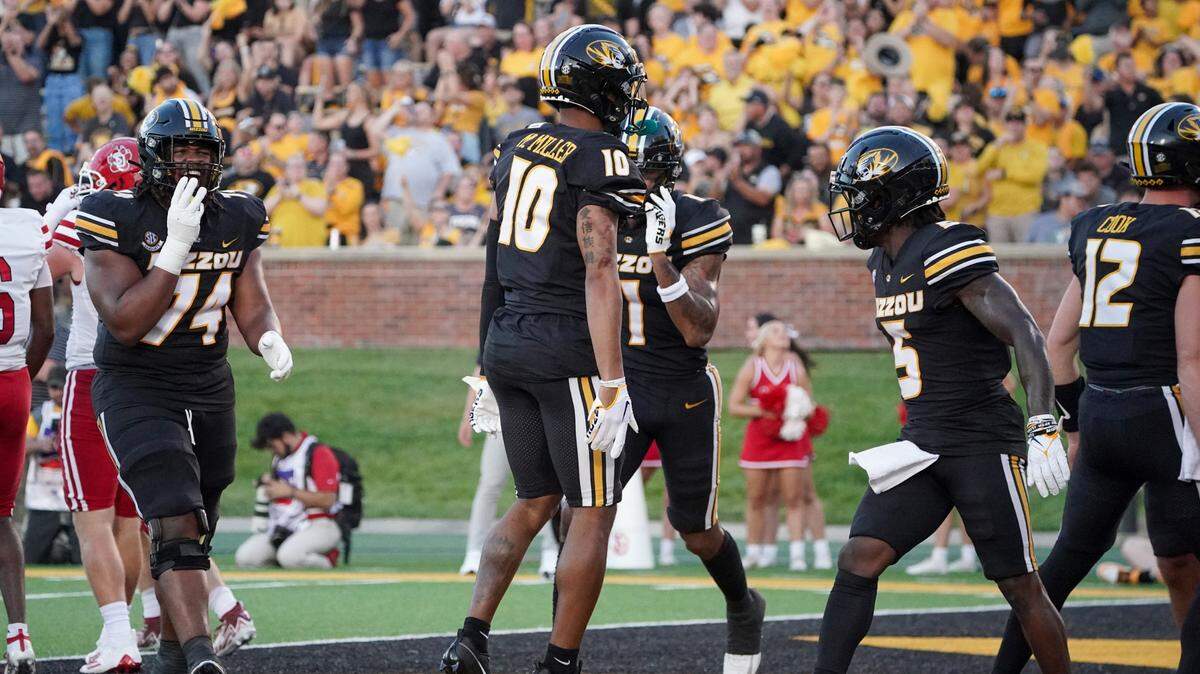 Missouri Tigers wide receiver Mekhi Miller (No. 10, and a Blue Valley North grad) celebrates with teammates after scoring the opening touchdown of Thursday night’s season-opening game against South Dakota on a pass from Brady Cook at Faurot Field in Columbia.