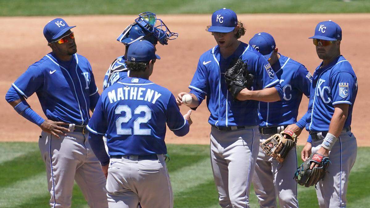 Kansas City Royals pitcher Jackson Kowar, third from right, hands the ball to manager Mike Matheny (22) as he is relieved during the second inning of a baseball game against the Oakland Athletics in Oakland, Calif., Saturday, June 12, 2021. (AP Photo/Jeff Chiu)