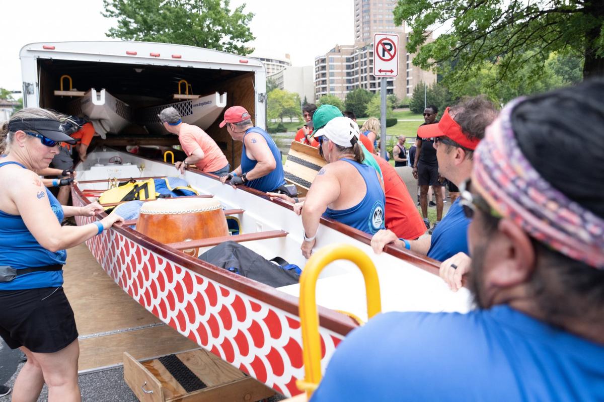 Dragon boat race team members help load the dragon boats into a trailer for storage after the 18th annual Kansas City Dragon Boat Festival on Saturday, June 15, 2024, along Brush Creek in Kansas City.