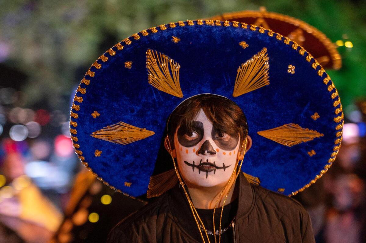 A parade participant walks the route during the Dia de los Muertos festival parade at the Mattie Rhodes Center.