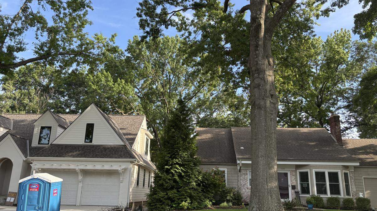 Jenny and Chris Garmons’ house (right) caught on fire last year when construction workers rebuilding a home on the lot next door used a backhoe to knock down a tree, ripping the electrical wires off the couple’s home.