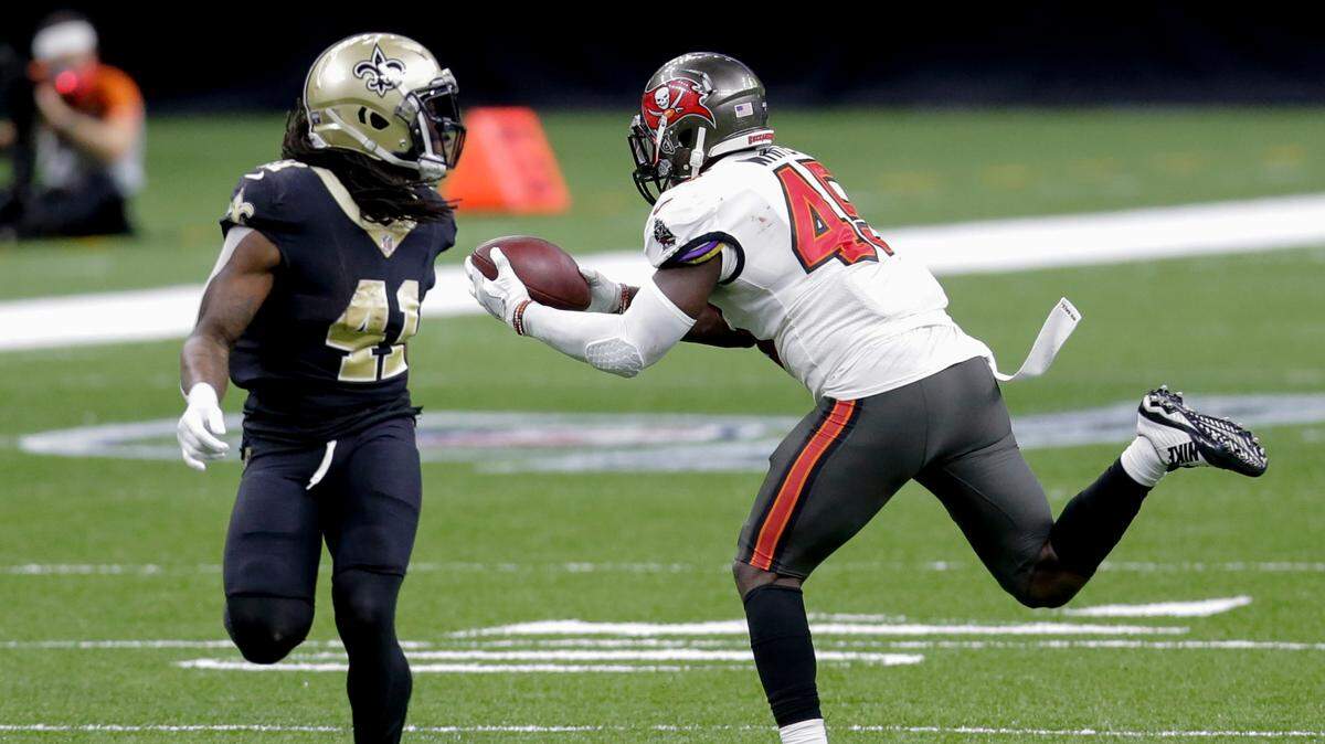 Tampa Bay Buccaneers inside linebacker Devin White, right, intercepts a pass in front of New Orleans Saints running back Alvin Kamara (41) during the second half of an NFL divisional round playoff football game, Sunday, Jan. 17, 2021, in New Orleans. (AP Photo/Brett Duke)