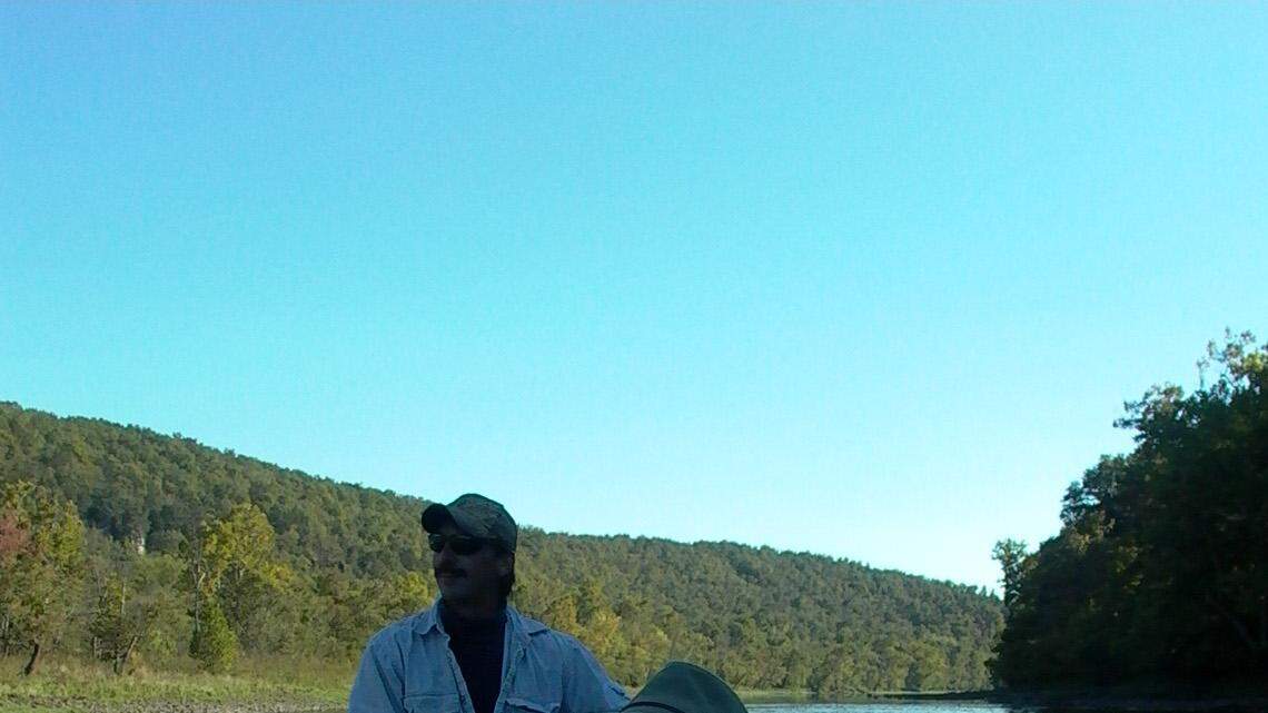 Walter Thompson looked at bluffs over the White River near Lakeview, Ark., as resort guide Ron Roderick (back) steered.