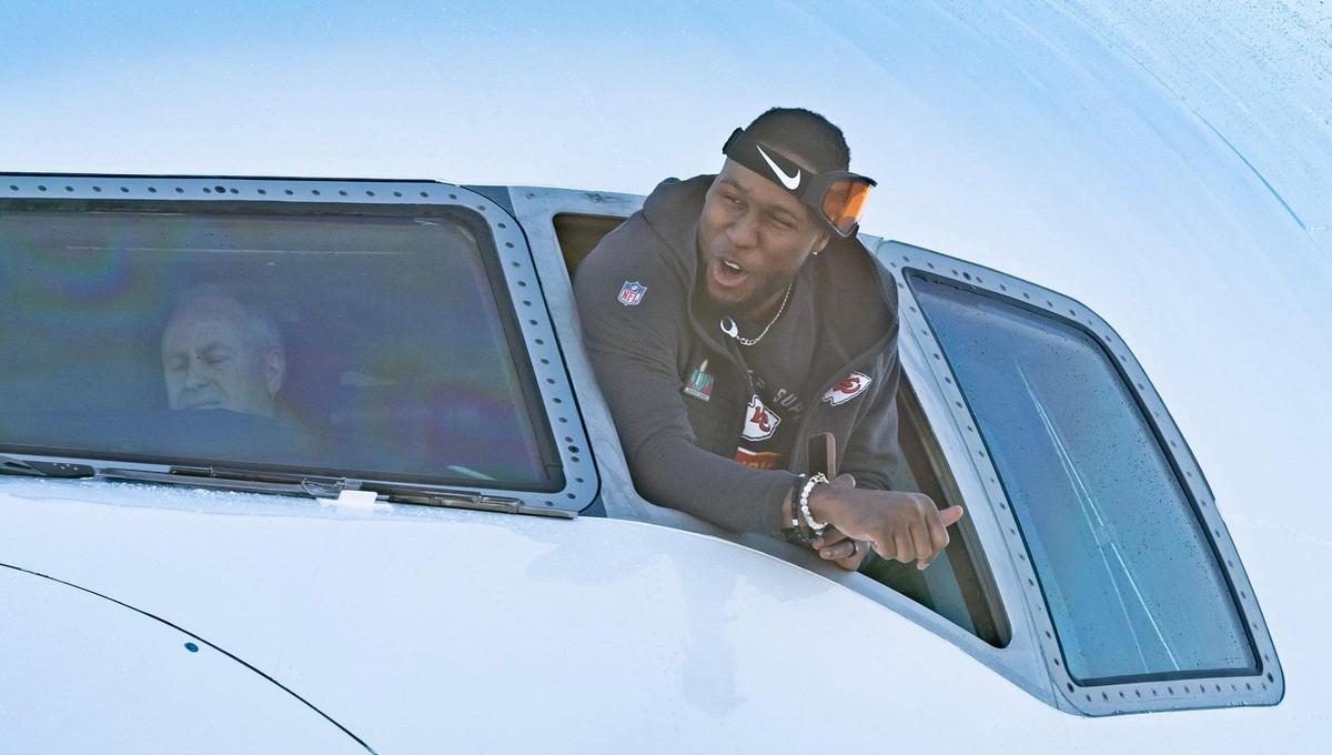 Chiefs defensive end Carlos Dunlap yells out the window of the team’s charter plane after it arrived at Kansas City International Airport on Monday. The Kansas City Chiefs returned home after defeating the Philadelphia Eagles in Super Bowl LVII in Glendale, Ariz.