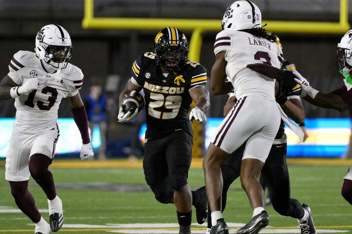 Ahmad Hardy #29 of the Missouri Tigers runs against Brylan Lanier #3 and Jahron Manning #13 of the Mississippi State Bulldogs during the first quarter at Faurot Field at Memorial Stadium on November 15, 2025 in Columbia.