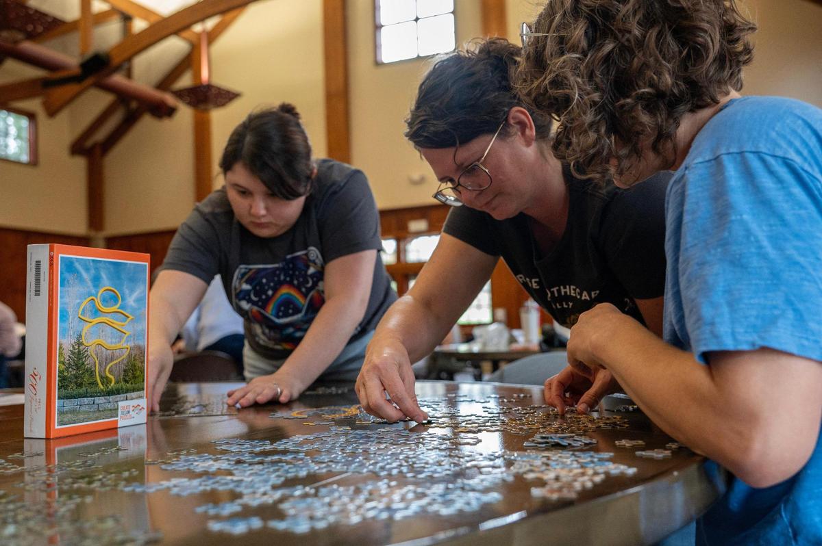 Amanda Hellburg, center, works on a 500-piece puzzle with her team, Wicker Kittens, during the Puzzle Palooza competition.