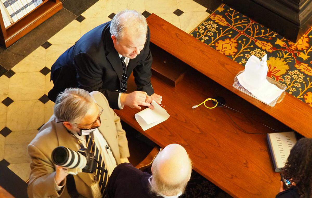 Senate spokesman Mike Pirner explains to Statehouse reporters John Hanna and Martin Hawver they can’t sit at the table for reporters on the Senate floor during the 2022 session.