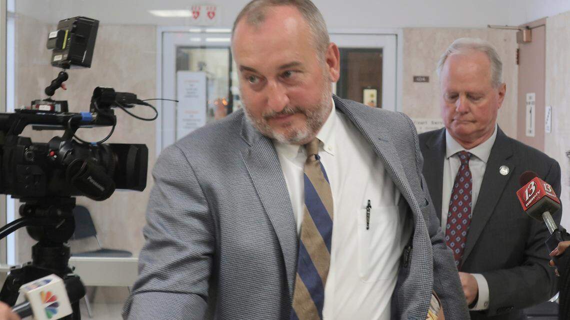 Attorney Tom Lemon, left, leads his client, former Kansas Senate Majority Leader Gene Suellentrop, right, through a crowd of reporters after a court hearing in which Suellentrop pleaded no contest to charges of driving under the influence and reckless driving, Monday, Oct. 25, 2021, in Topeka, Kan. The charges stem from an incident in March in which prosecutors say Suellentrop was speeding the wrong way down interstate highways in Topeka. (AP Photo/John Hanna)