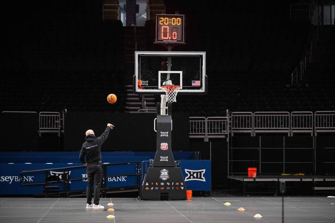 Employees of ASB GlassFloor test and finish installing the companies state-of-the-art glass LED basketball court, on Monday, March 2, 2026, at T-Mobile Center. The court, being used for the first time for a college basketball game, is controlled through a tablet which is capable of changing the look of the court at the press of a button.