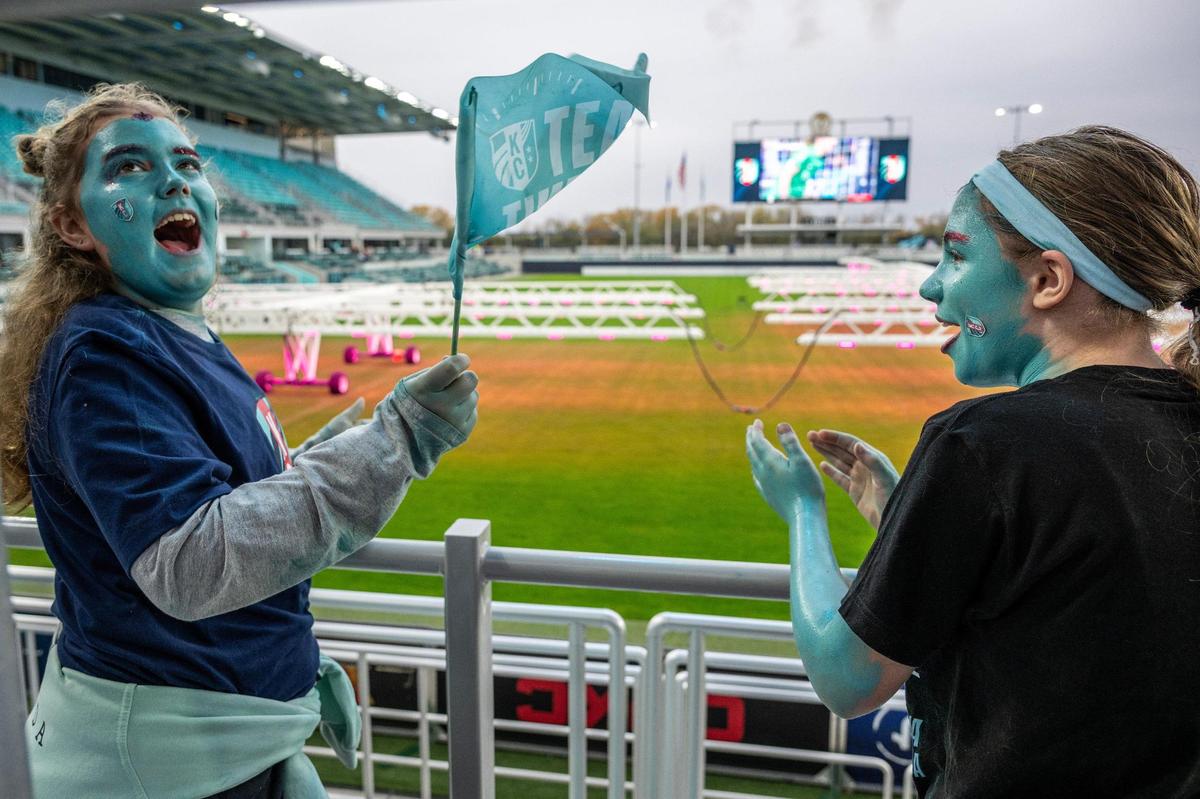 Ten-year-olds Emery Carpenter, left, and Dany Elrod, showing off teal face paint and red glitter eyebrows, celebrate after the Kansas City Current scored a goal during a watch party at CPKC Stadium for the semifinal match against Orlando Pride on Sunday, Nov. 17, 2024, in Kansas City.