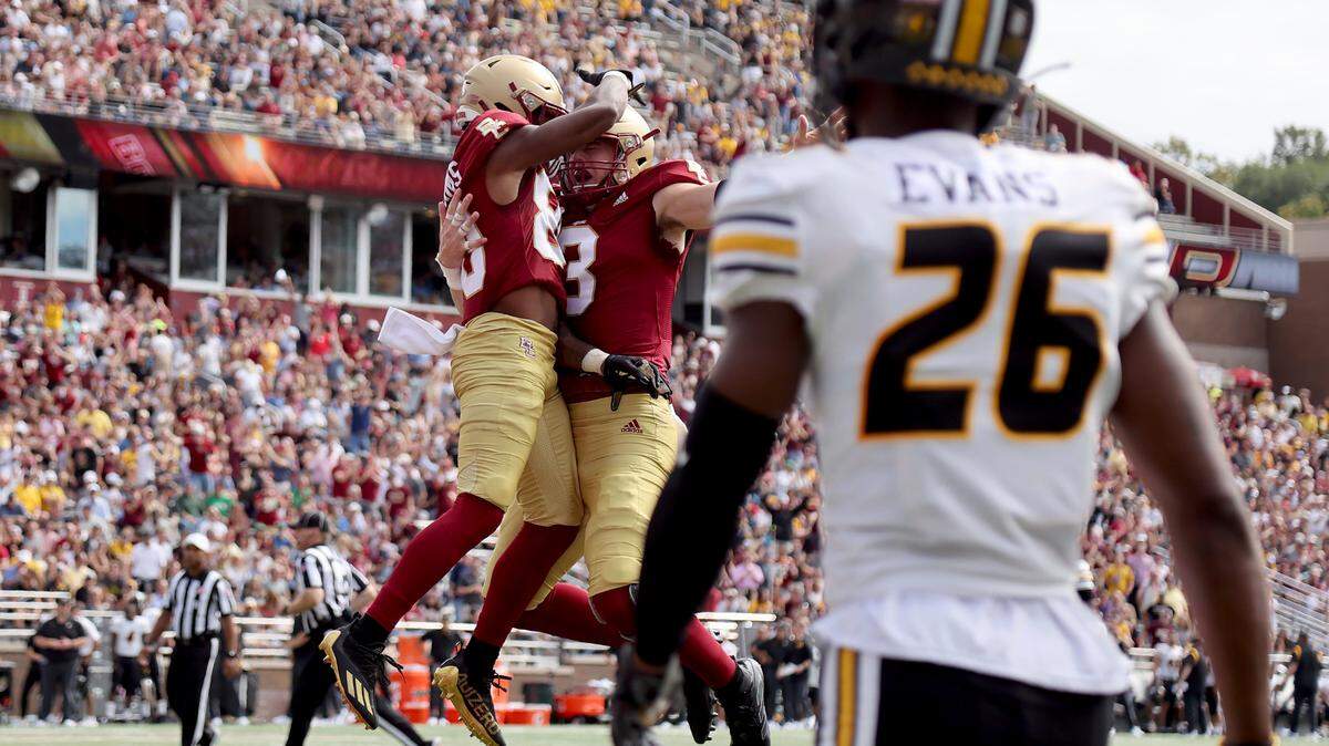 Boston College wide receiver Jaden Williams (80) is congratulated by quarterback Dennis Grosel (8) after scoring a touchdown as Missouri defensive back Akayleb Evans (26) looks on during the first half of an NCAA college football game, Saturday, Sept. 25, 2021, in Boston. (AP Photo/Mary Schwalm)