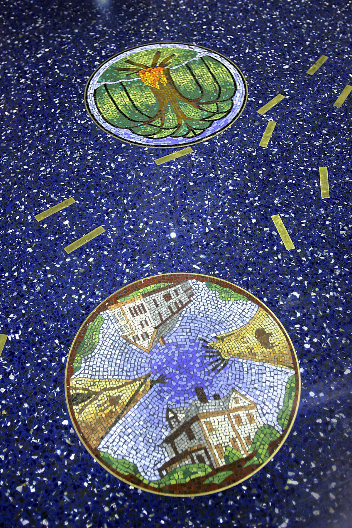 Two mosaic medallions are seen on the floor of Terminal B at Kansas City International Airport.