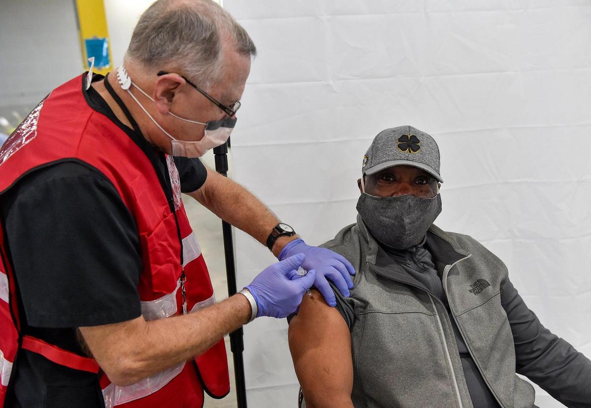 Volunteer Bob Katzenberger, a retired pharmacist, administers a COVID-19 vaccine dose to Gerry Blackwell of Platte City at a mass vaccination clinic in Riverside.
