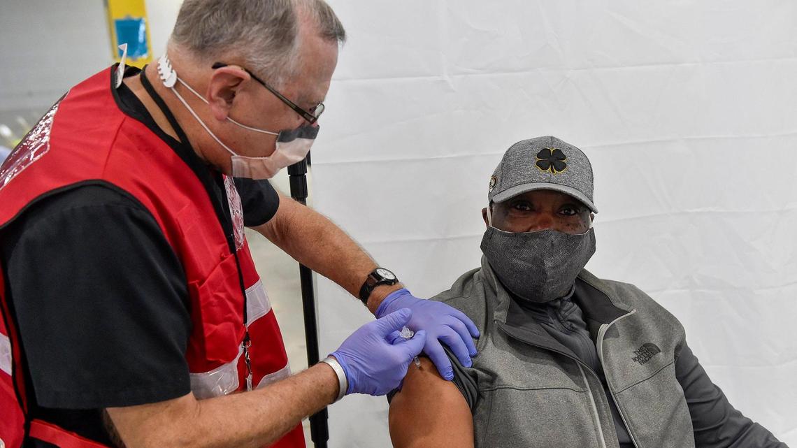 Volunteer Bob Katzenberger, a retired pharmacist, administers a COVID-19 vaccine dose to Gerry Blackwell of Platte City, 66. The Platte County Health Department opened a mass vaccination clinic in an unused warehouse in the Horizons Industrial Park in Riverside Tuesday, Mar. 2, 2021. The space was donated by NorthPoint Development.