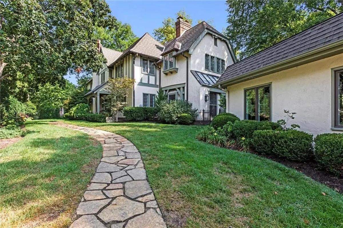 A stone walkway leads from a three-car garage to the home at 1234 W. 58th St. The century-old house is located in Kansas City near Ward Parkway and Mission Hills.