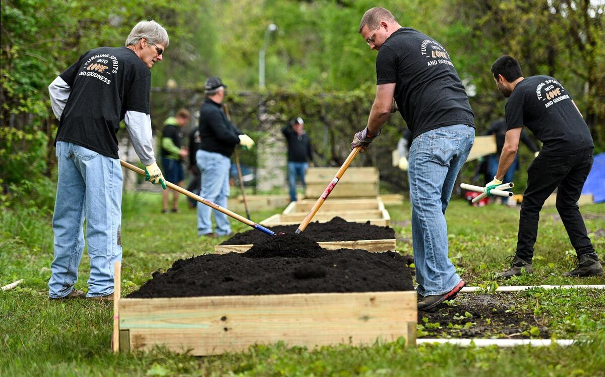 Steve Brady, left, and Kevin Stanbach level out the soil and compost mix in a new raised bed. They came out to volunteer with a group employed or associated with Henderson Engineers. A small army of volunteers helped give Freeway Park Community Garden in Kansas City’s historic Northeast a makeover for its 20th anniversary. The garden, near E. 14th Street and Indiana Avenue, is managed by Kansas City Community Gardens, which rents plots to neighborhood gardeners.