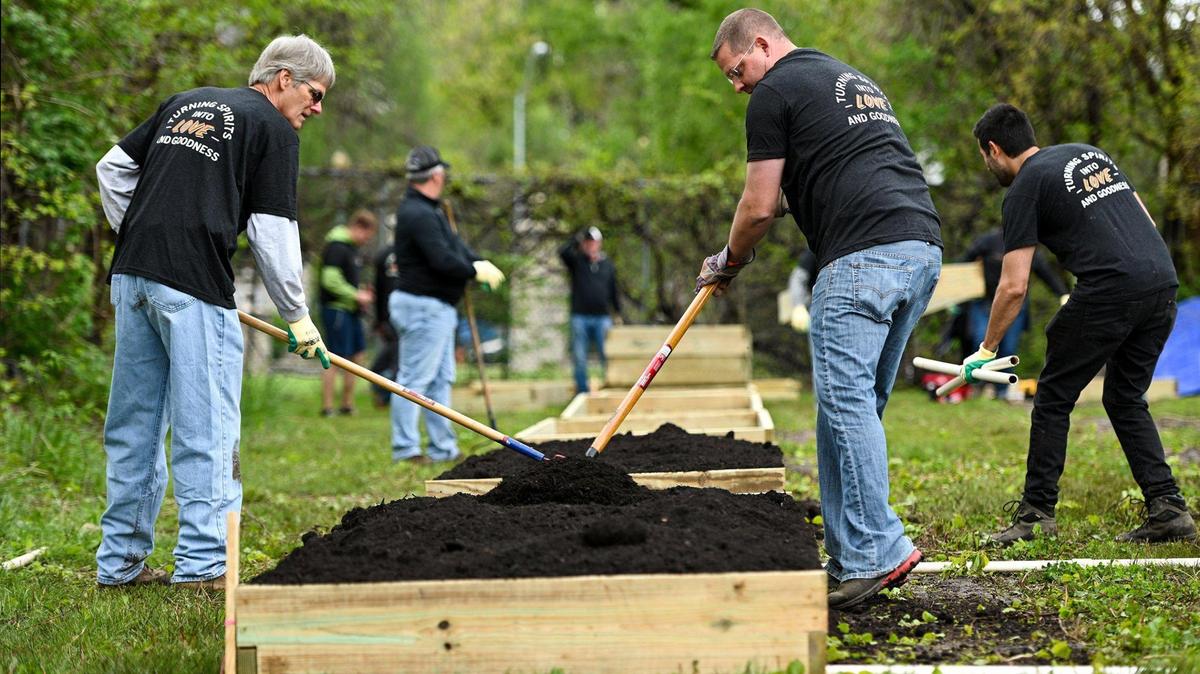 Steve Brady, left, and Kevin Stanbach level out the soil and compost mix in a new raised bed. They came out to volunteer with a group employed or associated with Henderson Engineers. A small army of volunteers helped give Freeway Park Community Garden in Kansas City’s historic Northeast a makeover for its 20th anniversary. The garden, near E. 14th Street and Indiana Avenue, is managed by Kansas City Community Gardens, which rents plots to neighborhood gardeners.