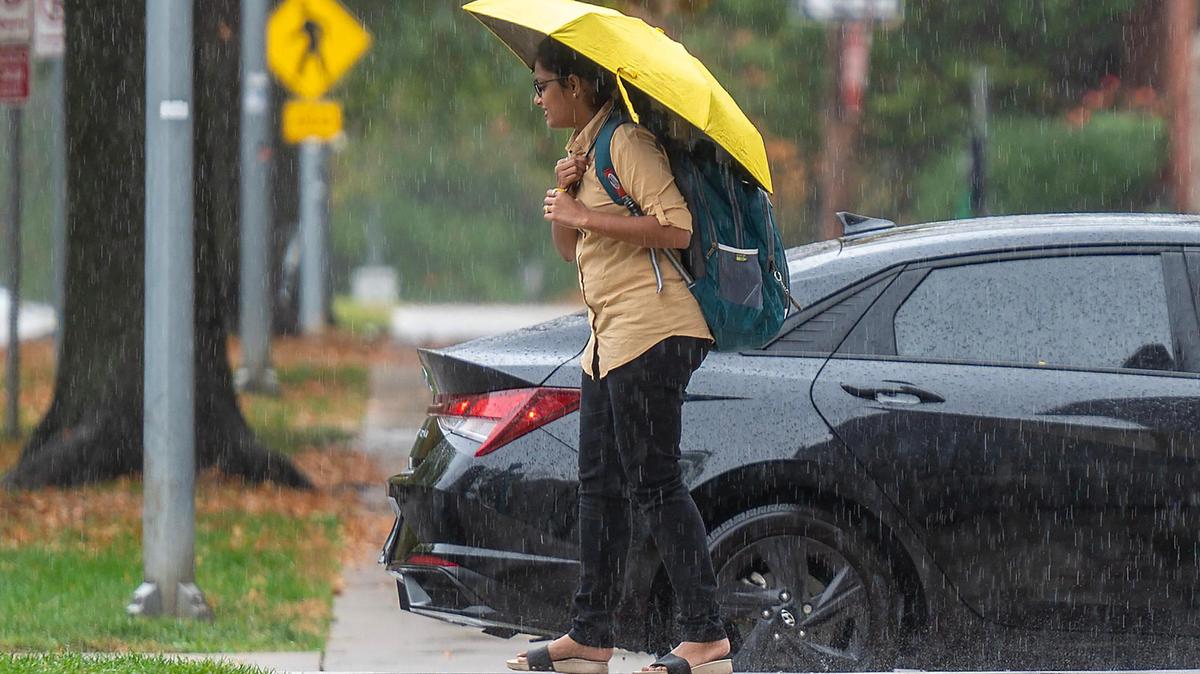 A commuter walks to board the bus near Armour Boulevard as heavy rain falls Wednesday in Kansas City.