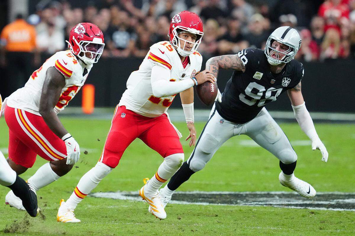 Kansas City Chiefs quarterback Patrick Mahomes (No. 15) is flushed out of the pocket by Las Vegas Raiders defensive end Maxx Crosby during a Sunday, Oct. 27, 2024 NFL Week 8 game at Allegiant Stadium in Paradise, Nevada.