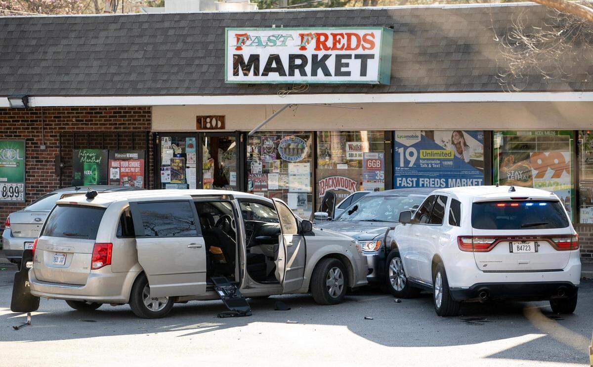 Vehicles at the scene of a shooting Wednesday in Kansas City, Kansas, show bullet holes and broken windshields on a suspect vehicle and a police car. Spend bullet casings, handgun magazines and police shields are seen on the ground.
