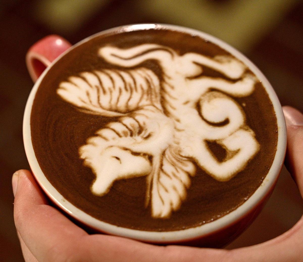 Edward Griffin shows a pegasus they created from latte art. After a turbulent and abusive childhood, Griffin found a sense of belonging in the coffee community. 