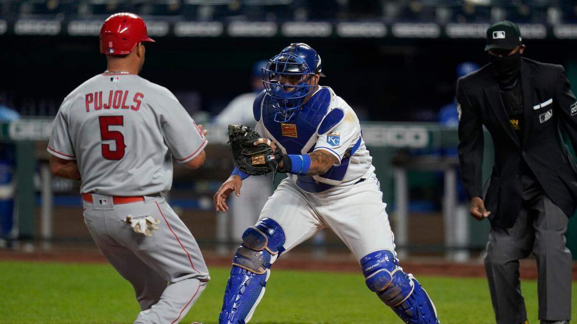 Kansas City Royals catcher Salvador Perez, right, forces out Los Angeles Angels Albert Pujols (5) during the sixth inning of a baseball game at Kauffman Stadium in Kansas City, Mo., Tuesday, April 13, 2021. (AP Photo/Orlin Wagner)