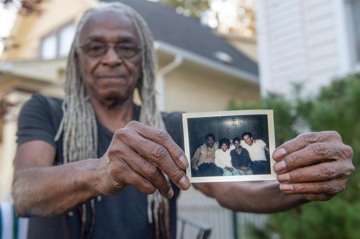 Mickey Sutherlin, 71, holds an old family photo of, from right, his father, mother, aunt and uncle. His father, Leroy Adams, died at age 49 on his way home in the 1977 Brush Creek flood.