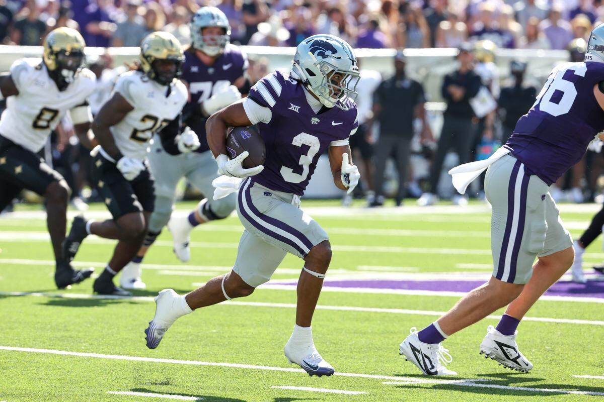 Kansas State Wildcats running back Dylan Edwards eludes would-be tacklers on a gain against the UCF Knights at Bill Snyder Family Stadium in Manhattan, Kansas on Saturday, Sept. 27, 2025.
