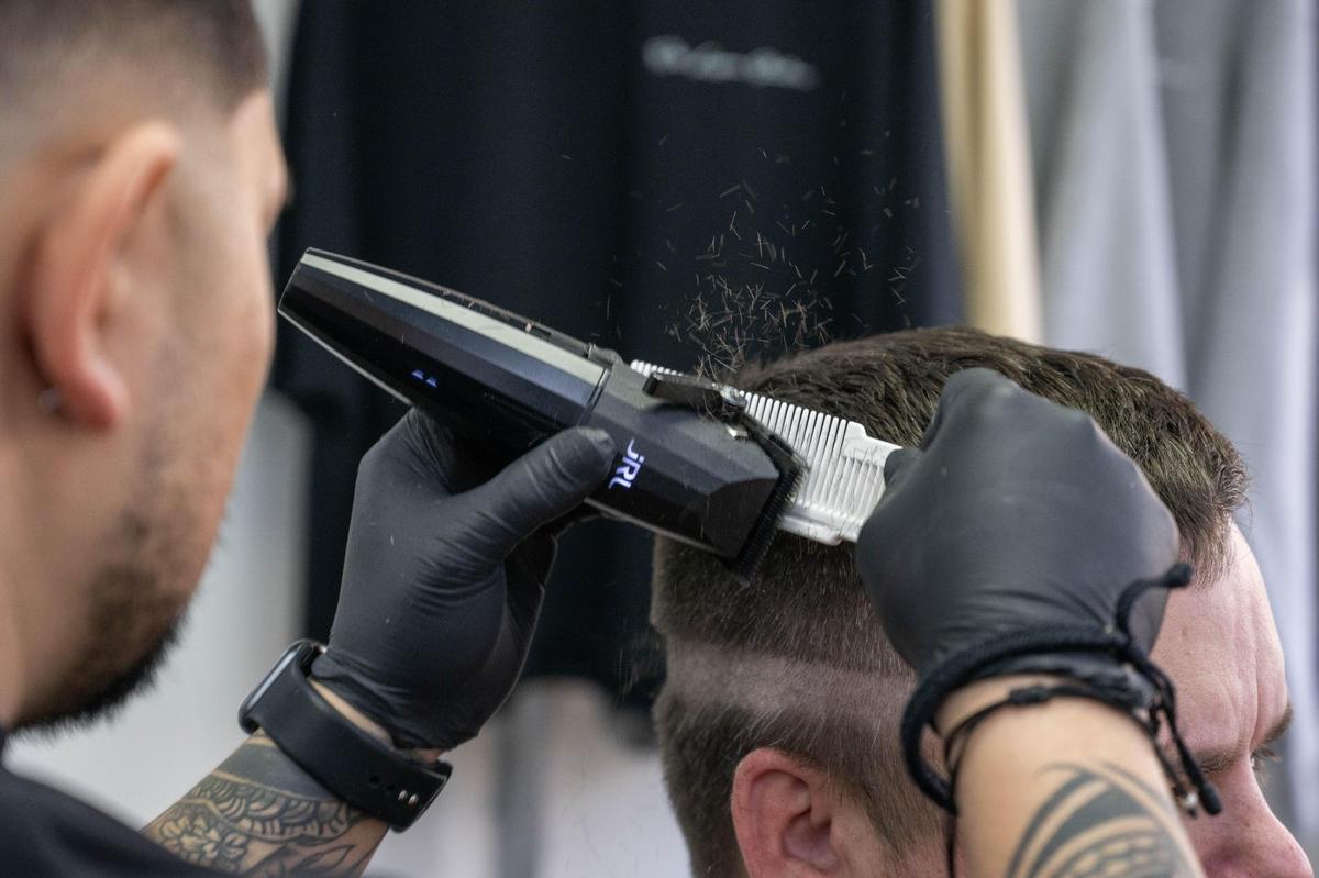 Josh Pacubas trims a client’s hair at his barbershop. Since opening his shop, Pacubas, 32, has created a welcoming environment that is open to people of all backgrounds.