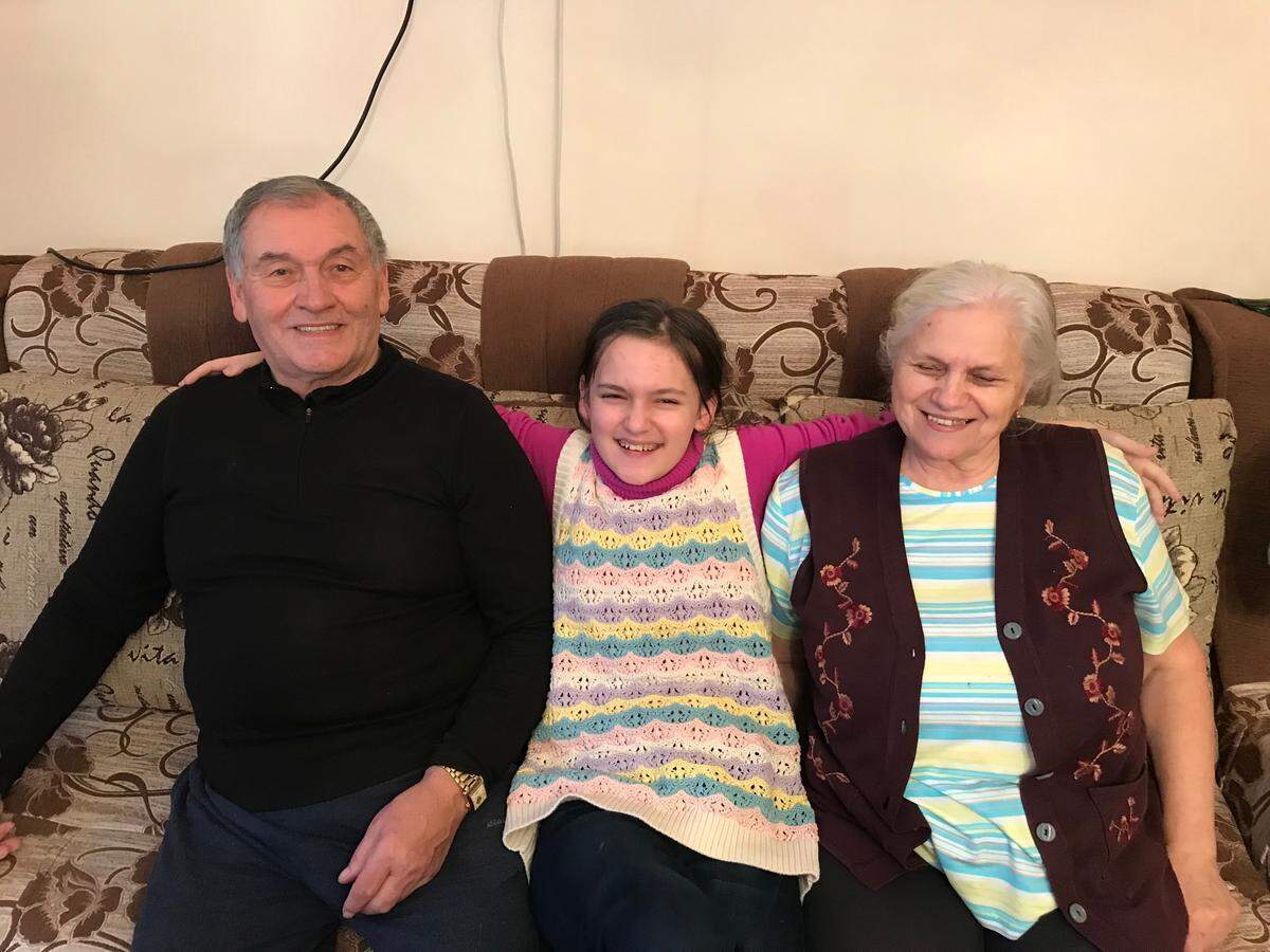 Solomia Beregovska sits with her maternal grandmother, 74, and grandfather, 75, at their home in Ivano-Frankivsk, Ukraine.