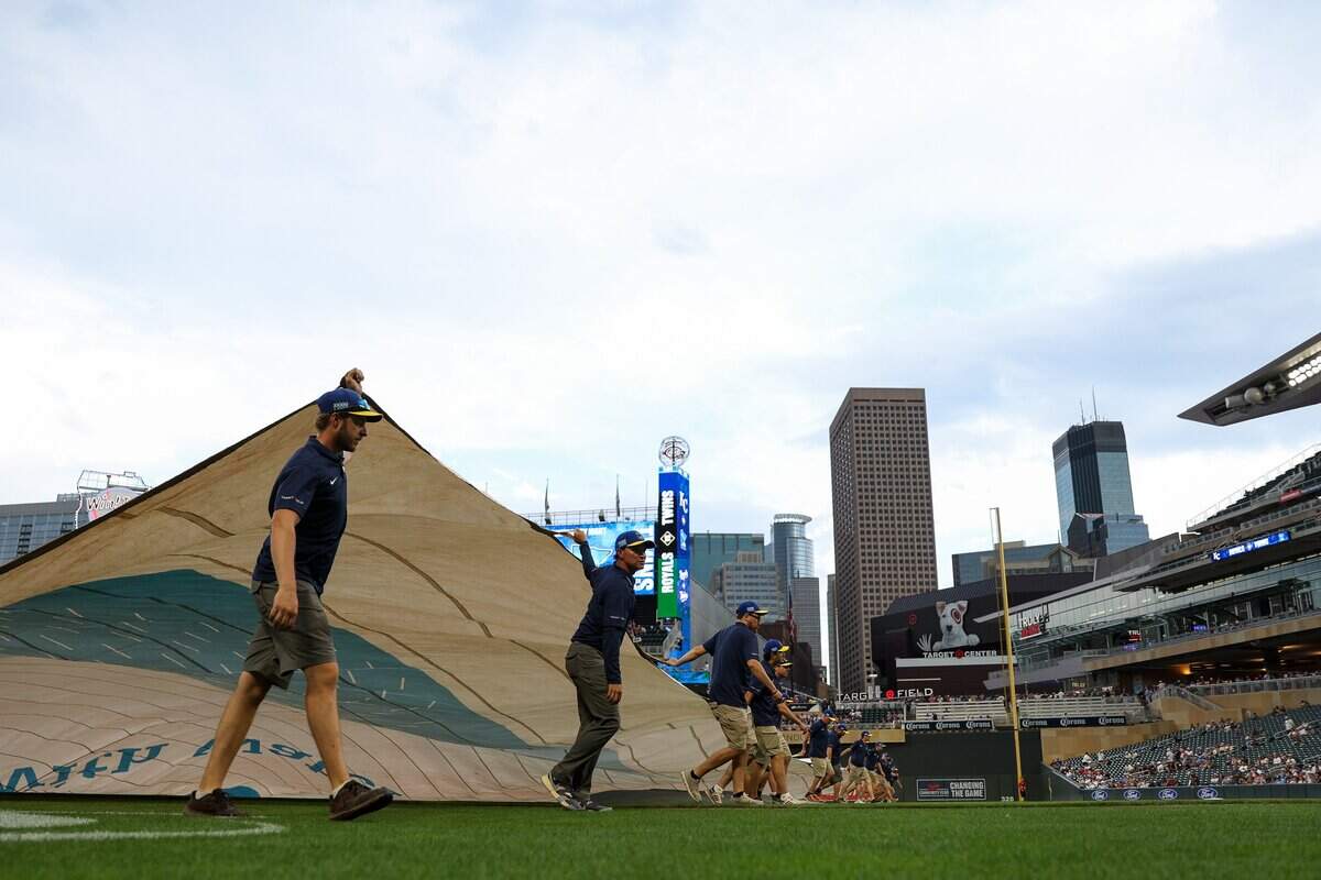 MINNEAPOLIS, MINNESOTA - JUNE 05: Members of the Target Field grounds crew pulls a tarp over the field during a rain delay prior to the game between the Minnesota Twins and the Kansas City Royals at Target Field on June 5, 2026 in Minneapolis, Minnesota. (Photo by Matt Krohn/Getty Images)